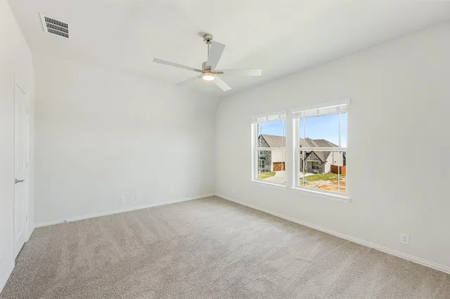 an empty room with a window and ceiling fan