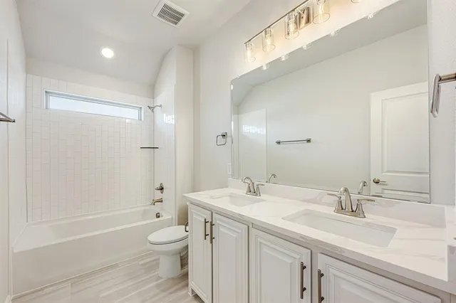 a bathroom with a granite countertop sink a toilet and a large mirror