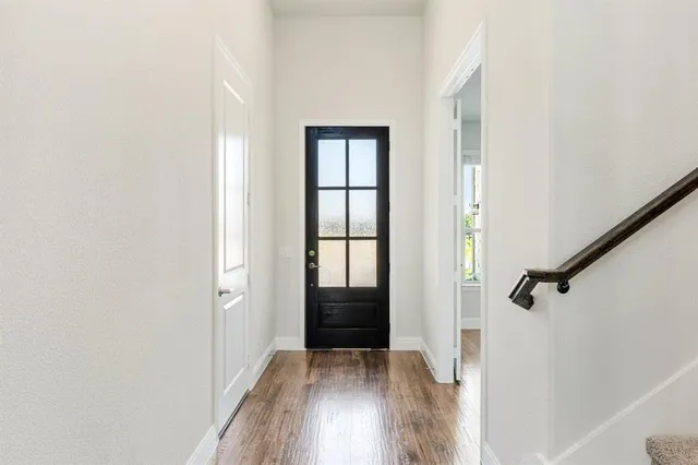 a view of a hallway with wooden floor and closet