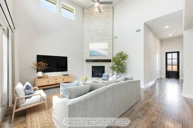 a living room with furniture a flat screen tv and a fireplace