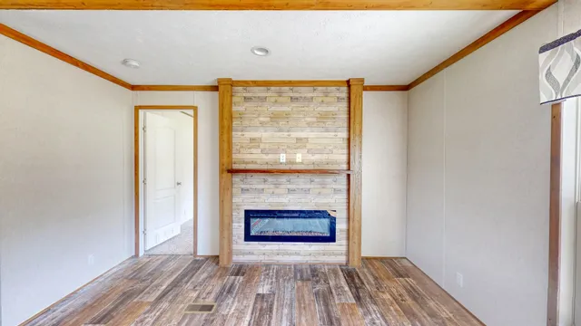 a view of empty room with wooden floor and fireplace