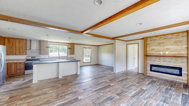 a view of a kitchen with a sink and dishwasher a refrigerator with wooden floor
