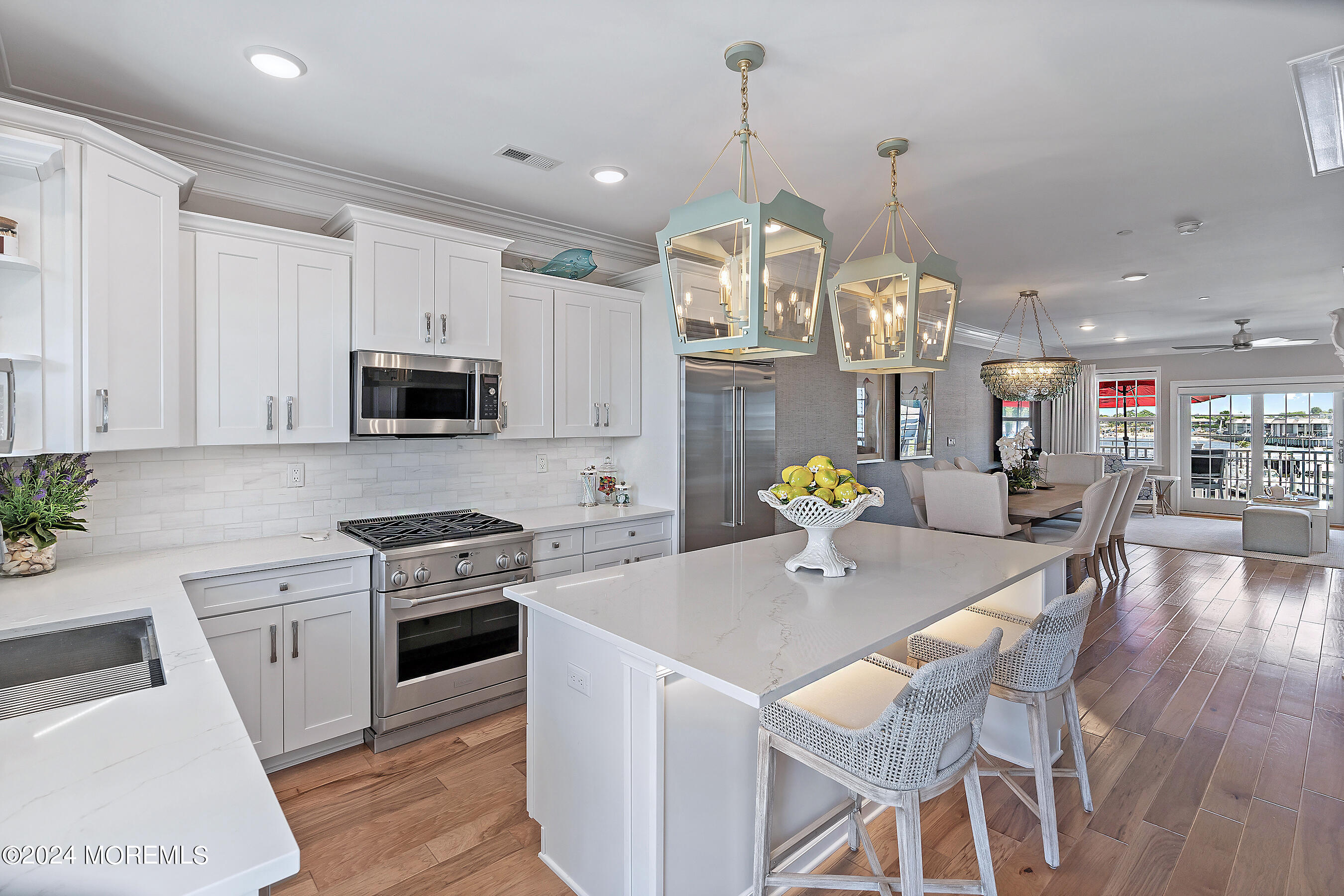 8 Lighthouse Point Road, Unit 703 Highlands, NJ 07732 - Photo 7 of 43 a kitchen with stainless steel appliances kitchen island granite countertop a stove a sink dishwasher a dining table and chairs with wooden floor