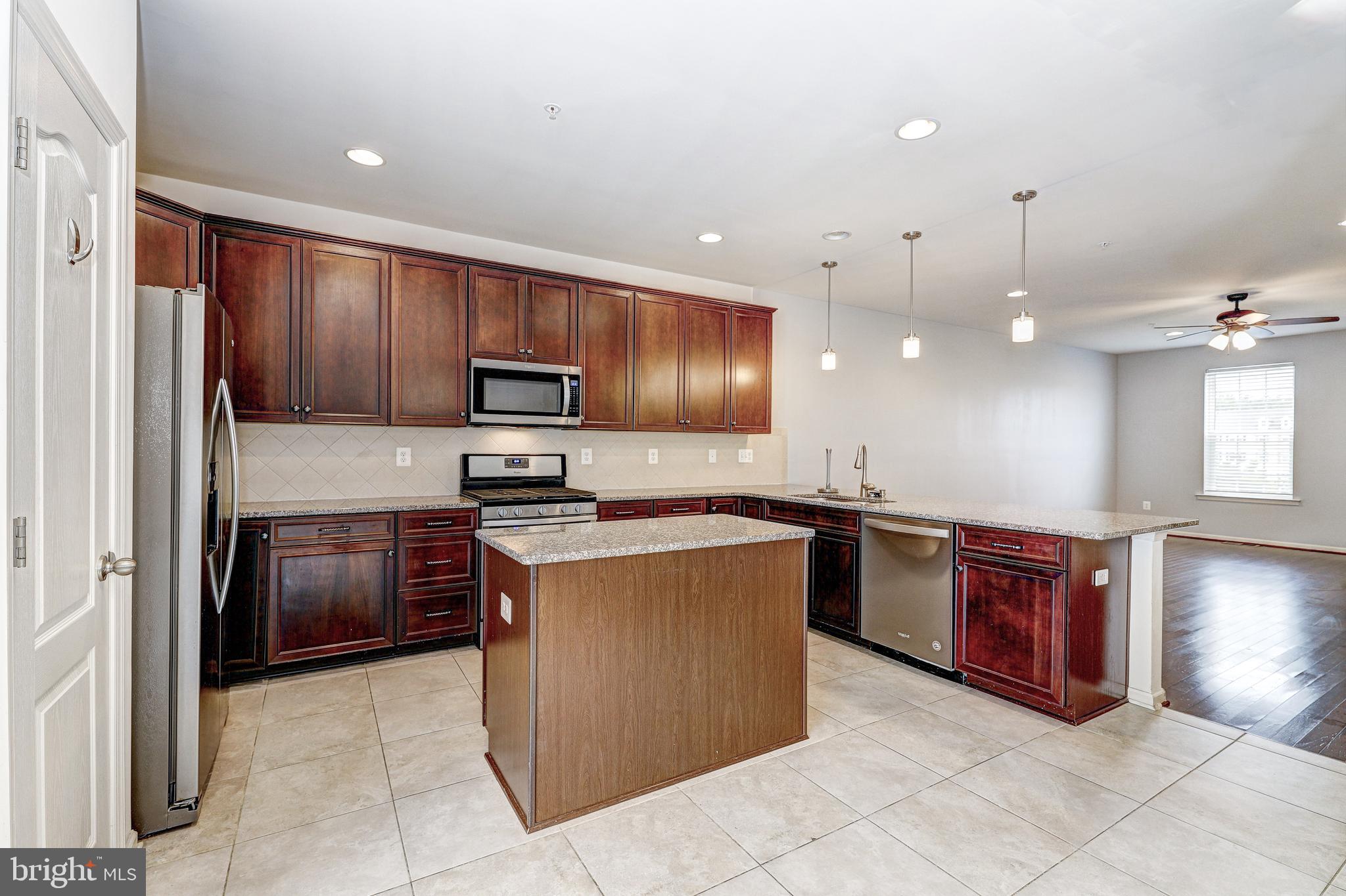 912 Winter Run Road Middle River, MD 21220 - Photo 13 of 55 a kitchen with stainless steel appliances granite countertop wooden cabinets a stove a sink and a refrigerator