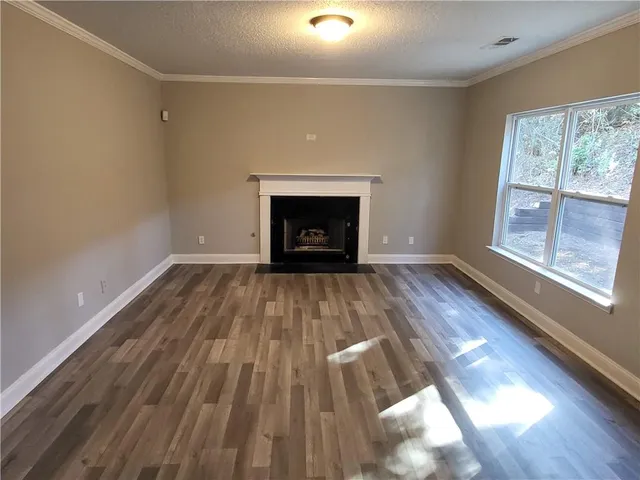 a view of empty room with wooden floor and fireplace