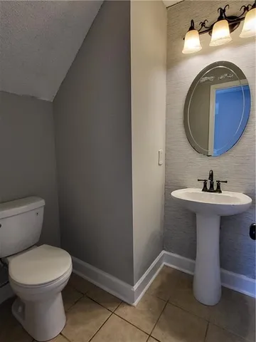 a bathroom with a sink toilet and a mirror