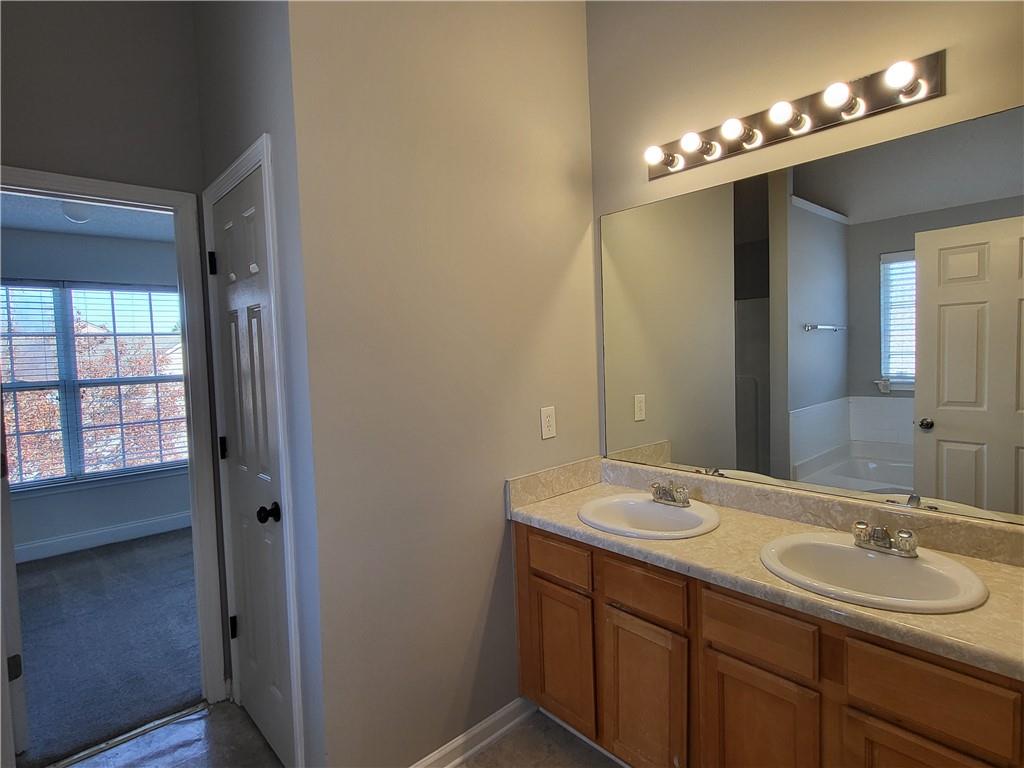4234 Winston Circle Atlanta, GA 30349 - Photo 10 of 19 a bathroom with a double vanity sink and a mirror