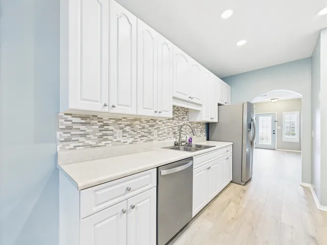 a kitchen with white cabinets stainless steel appliances and sink