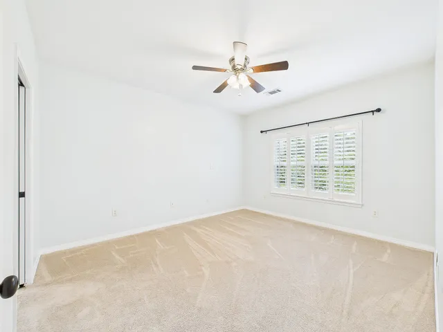 an empty room with closet and a chandelier fan