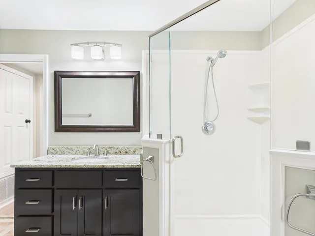a bathroom with a granite countertop sink and a mirror