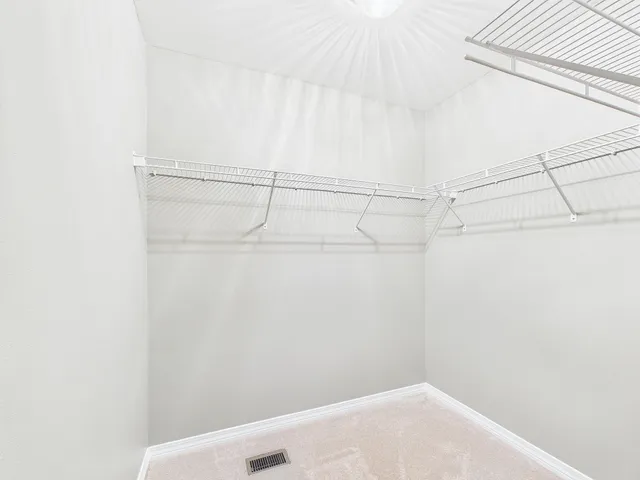 an empty room with windows and chandelier fan