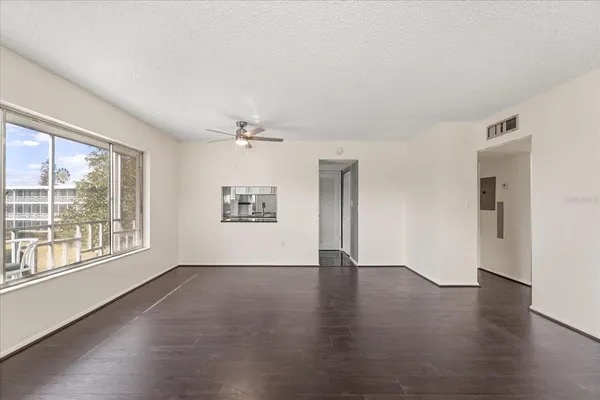 an empty room with wooden floor and windows