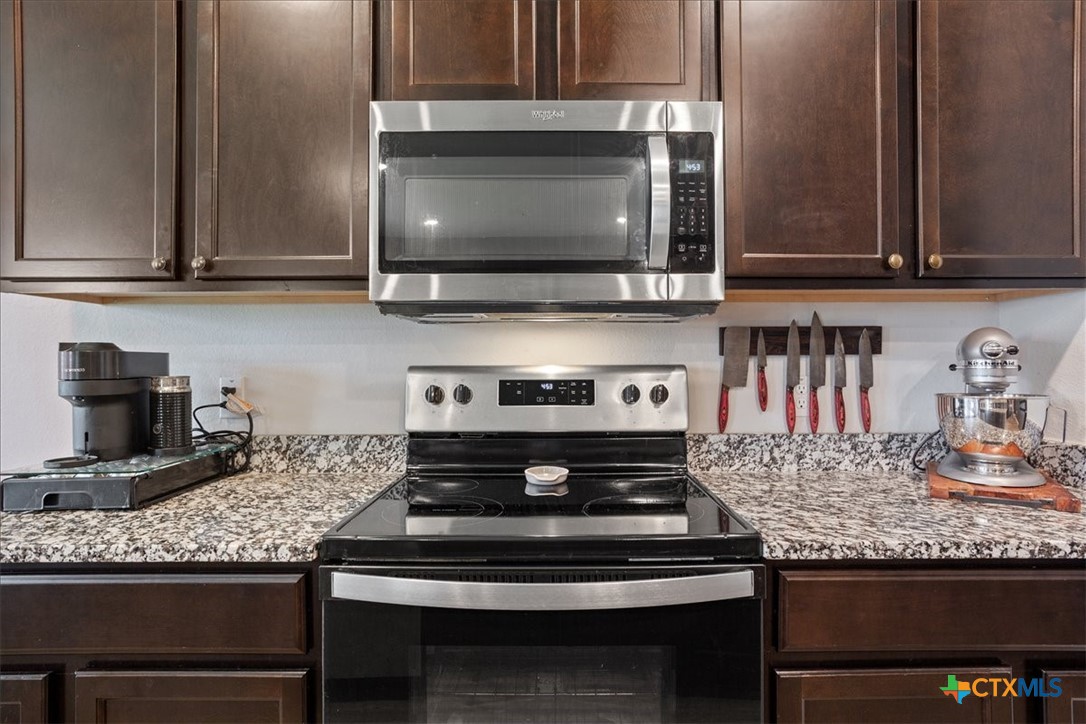 1000 Velvet Court Troy, TX 76579 - Photo 11 of 25 a kitchen with granite countertop a stove and a microwave