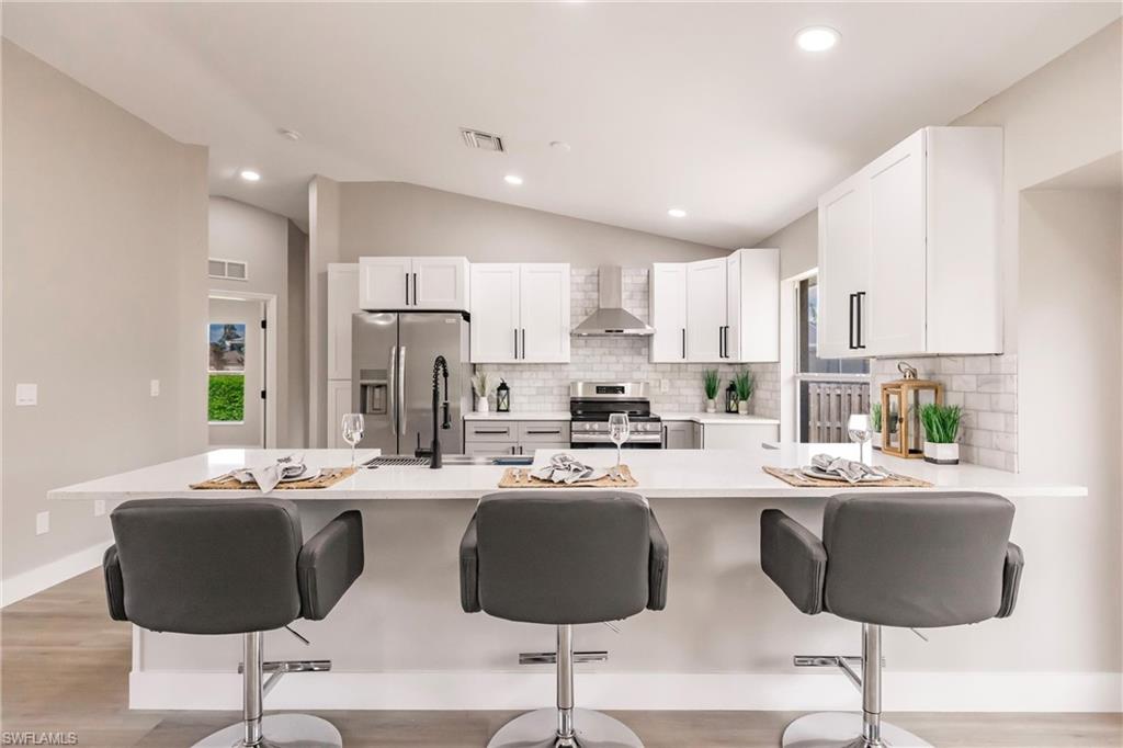 18289 Hepatica Road Fort Myers, FL 33967 - Photo 17 of 45 a kitchen with stainless steel appliances kitchen island granite countertop a dining table and chairs
