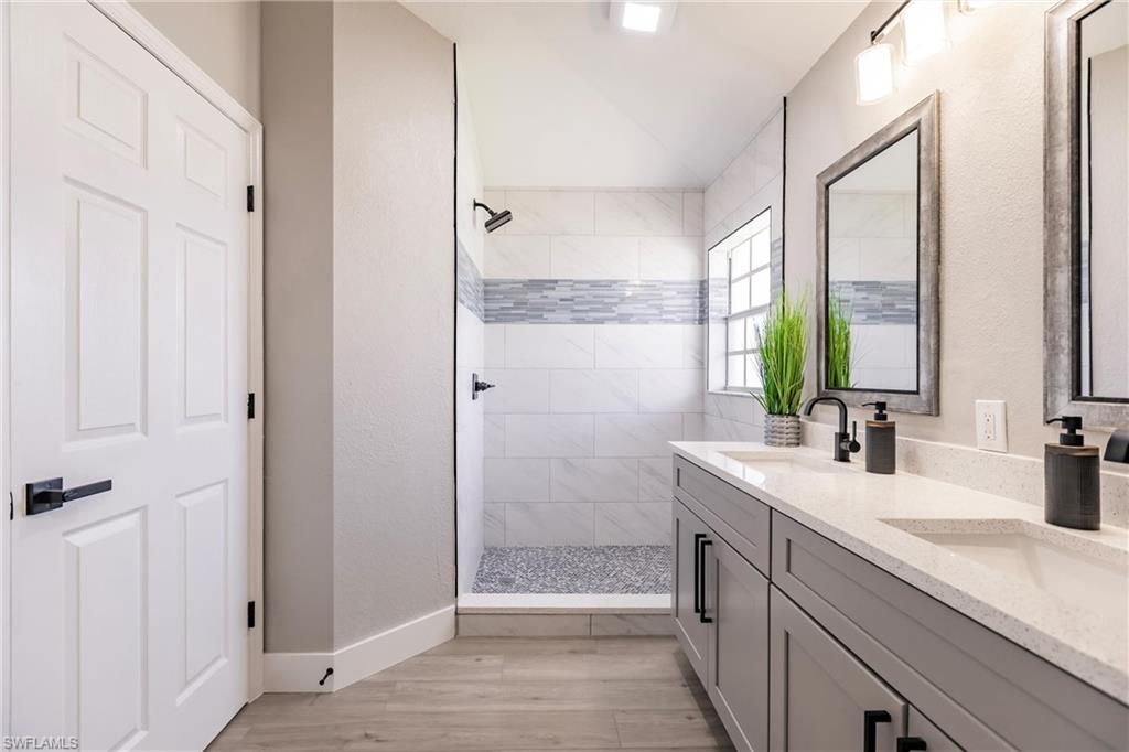 18289 Hepatica Road Fort Myers, FL 33967 - Photo 25 of 45 a bathroom with a double vanity sink a mirror and a shower