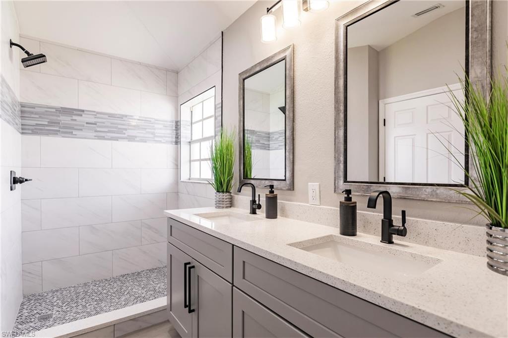 18289 Hepatica Road Fort Myers, FL 33967 - Photo 26 of 45 a bathroom with a double vanity sink a mirror and a shower