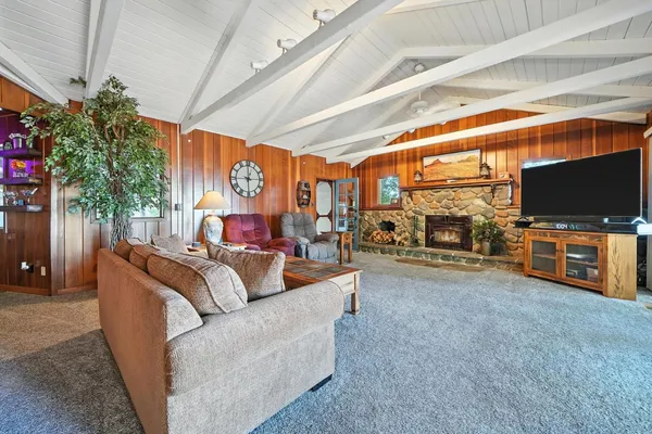 a kitchen with stainless steel appliances granite countertop a stove a sink dishwasher a dining table and chairs with wooden floor