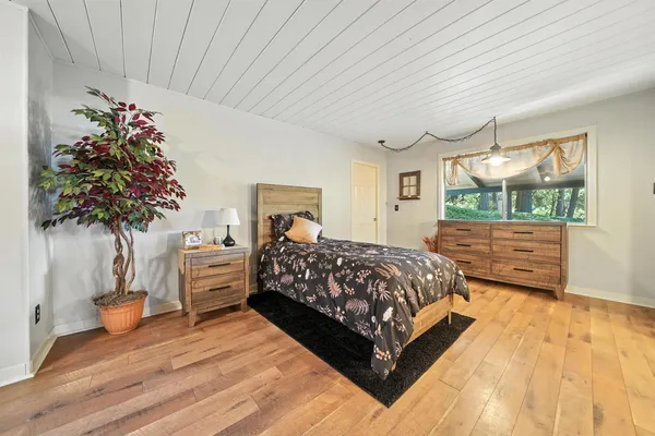 a bedroom with a bed a flat screen tv and dresser