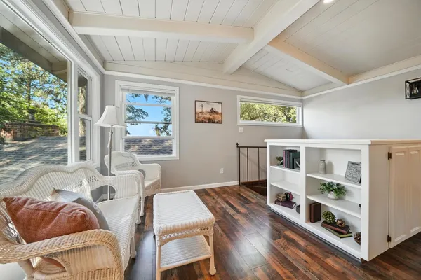 a bedroom with a bed next to a window with a chandelier
