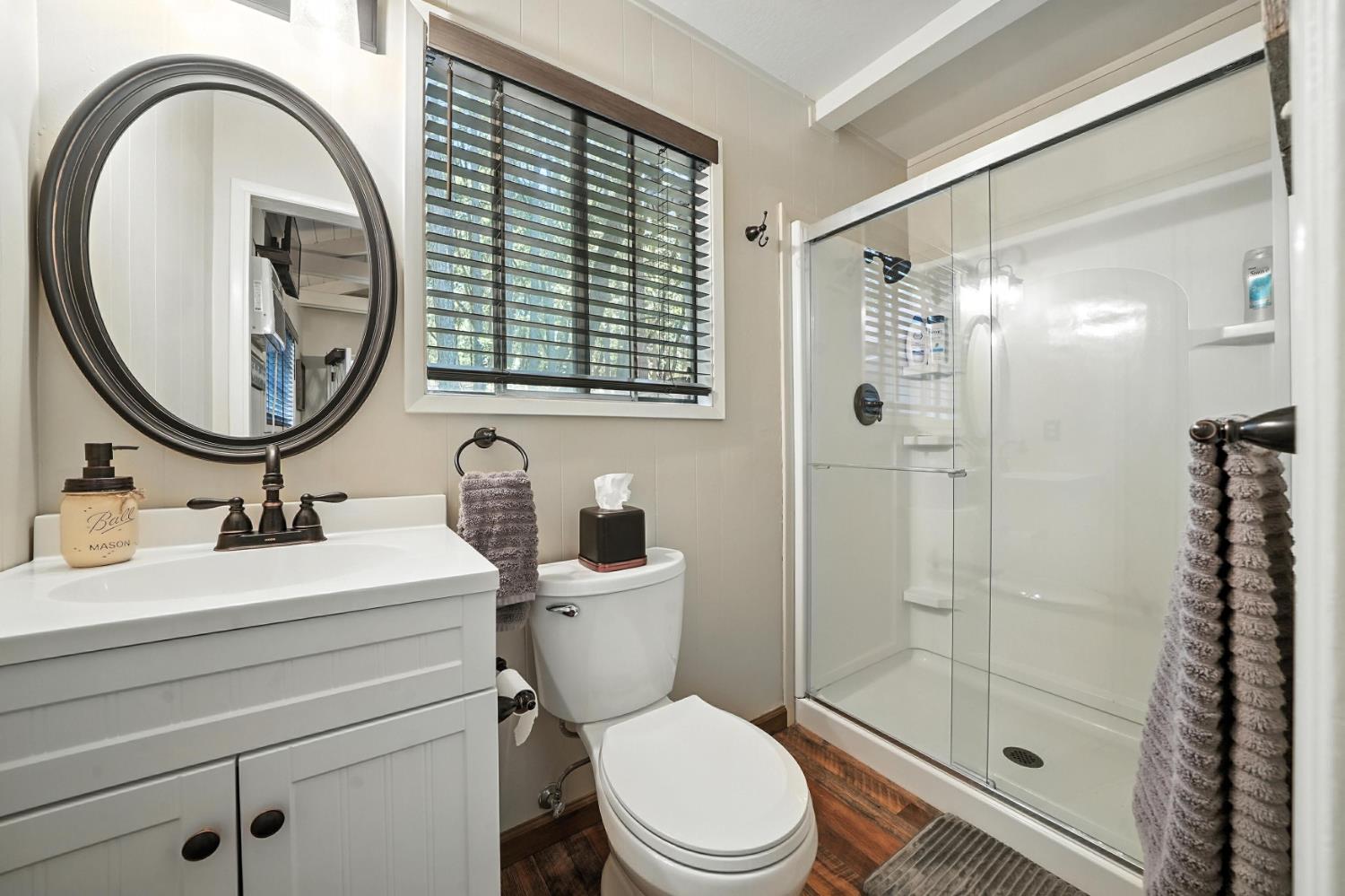 19630 Charleston Road Volcano, CA 95689 - Photo 52 of 70 a bathroom with a toilet a sink a mirror and shower