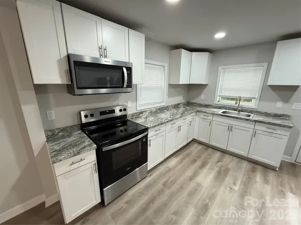 a kitchen with a sink stove and microwave