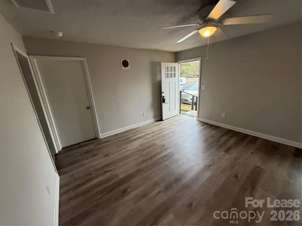 an empty room with wooden floor and windows