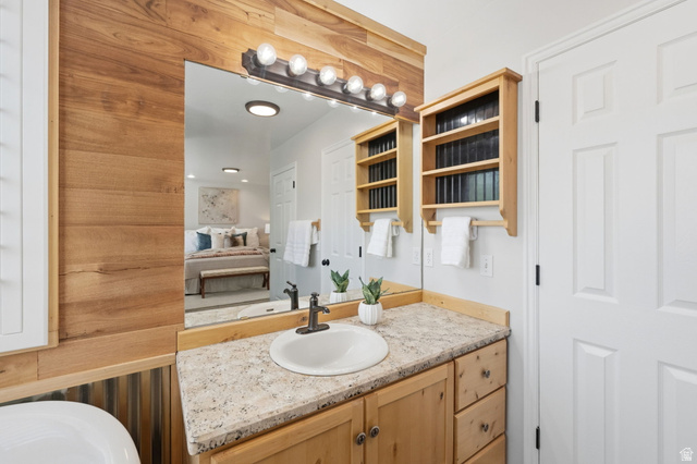 3732 Campbell Road Tooele, UT 84074 - Photo 33 of 69 Bathroom vanity with a round undermount sink, granite-style countertop, natural wood cabinetry, and a multi-bulb light fixture