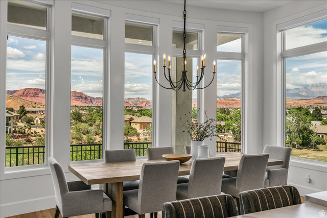2608 Canyon Ridge Drive St. George, UT 84770 - Photo 19 of 86 Spacious dining area featuring expansive windows, a prominent chandelier, and wood-finish flooring