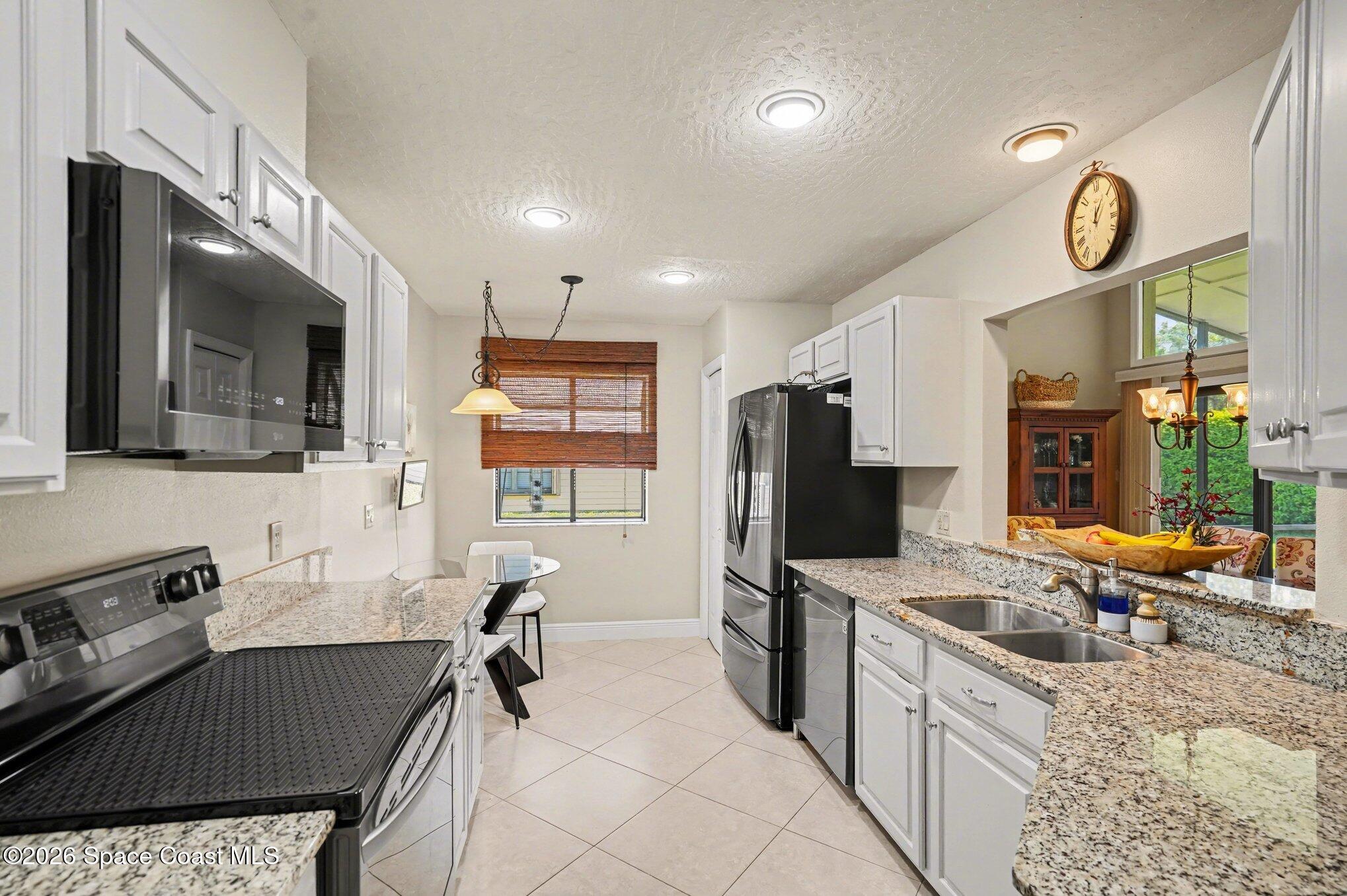 873 Ridge Lake Drive Melbourne, FL 32940 - Photo 11 of 27 a kitchen that has a lot of cabinets a refrigerator and a stove