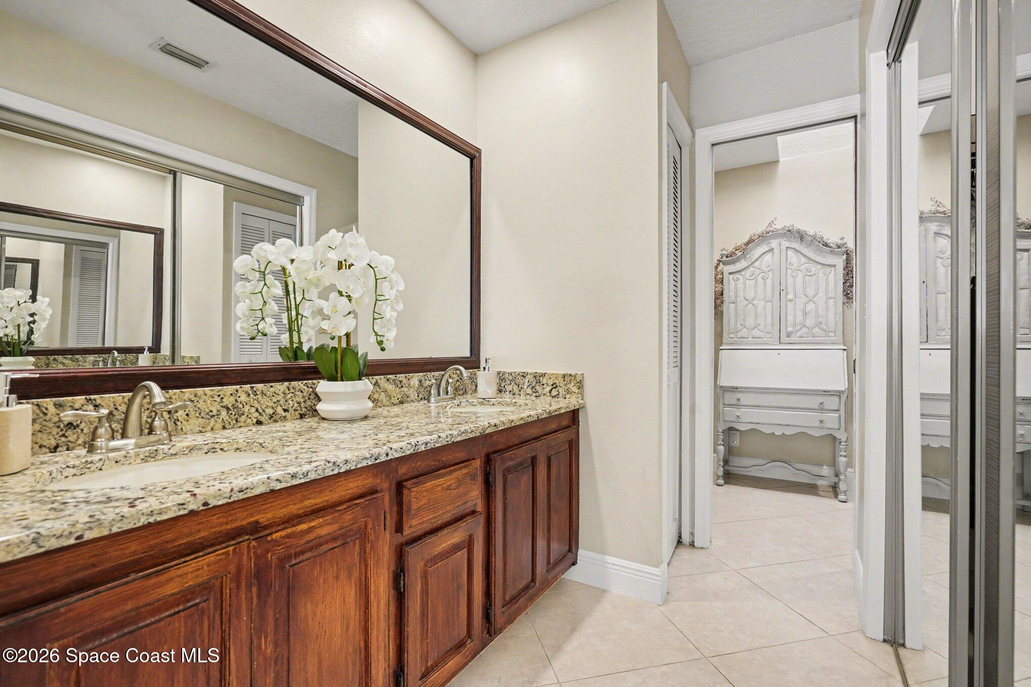 873 Ridge Lake Drive Melbourne, FL 32940 - Photo 16 of 27 a bathroom with a granite countertop sink and a mirror
