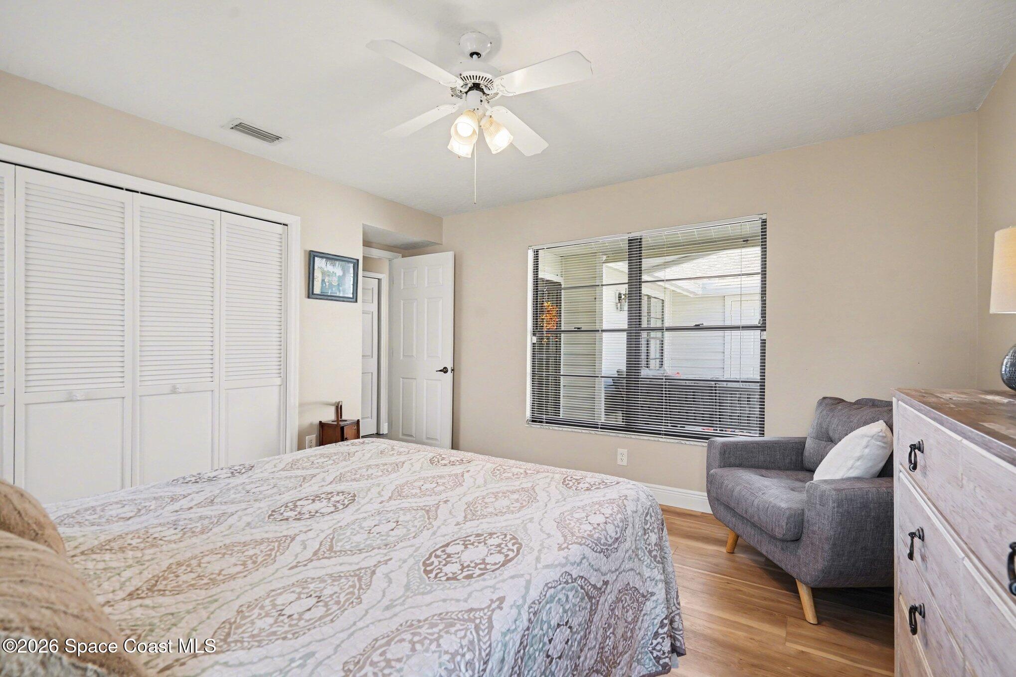 873 Ridge Lake Drive Melbourne, FL 32940 - Photo 19 of 27 a bedroom with a large bed couch and windows