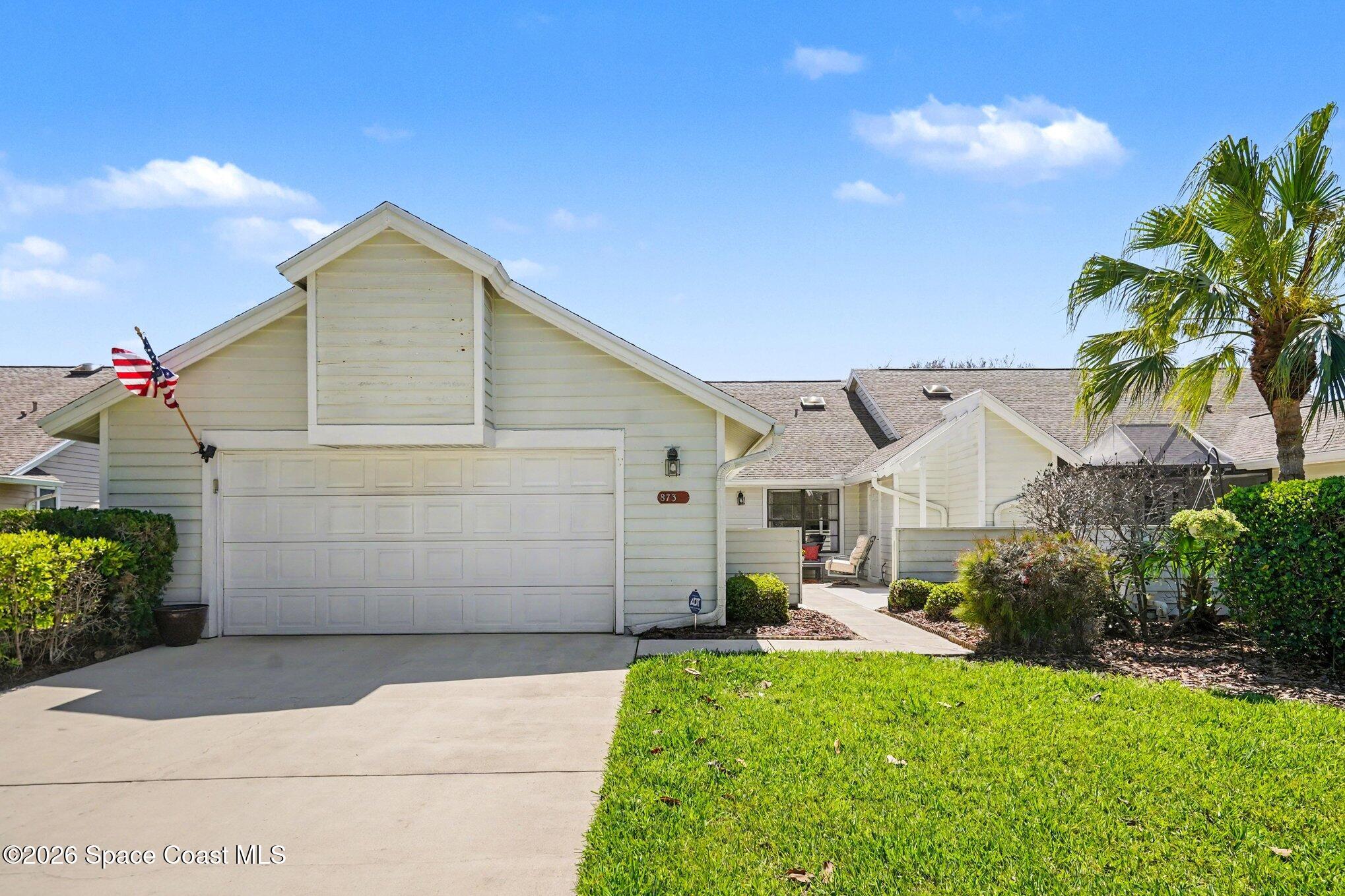 873 Ridge Lake Drive Melbourne, FL 32940 - Photo 2 of 27 a front view of a house with a yard and garage