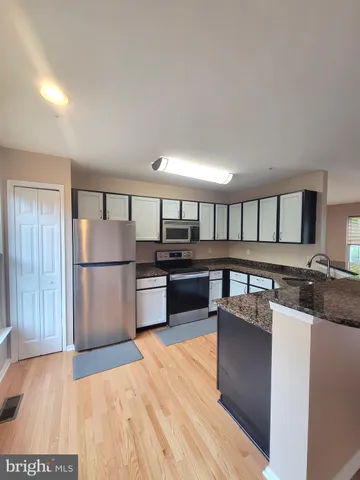 a kitchen with stainless steel appliances granite countertop a refrigerator and a stove