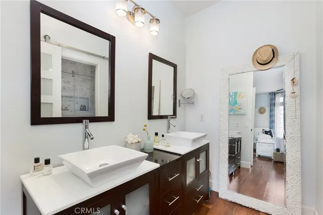 a bathroom with double vanity sinks a mirror and a shower