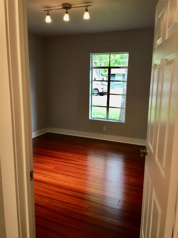 3705 Grayson Lane Austin, TX 78722 - Photo 12 of 17 an empty room with wooden floor and windows with curtains