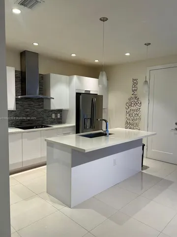 a large kitchen with stainless steel appliances a large counter top