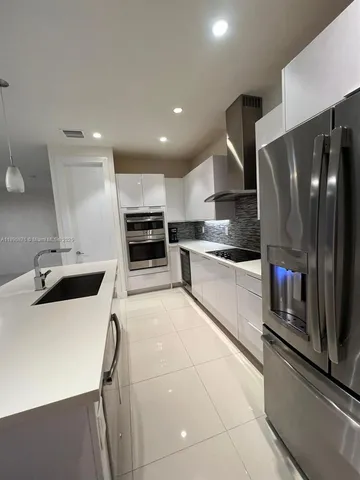 a kitchen with stainless steel appliances a refrigerator sink and stove