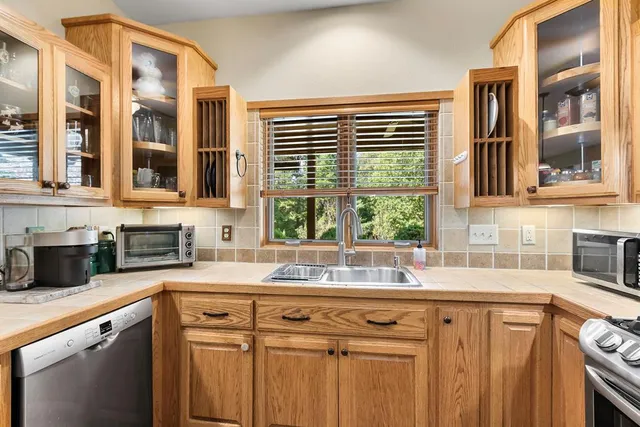 a view of an empty room with a window and a kitchen