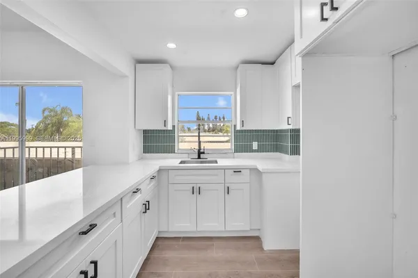 a kitchen with sink cabinets and window