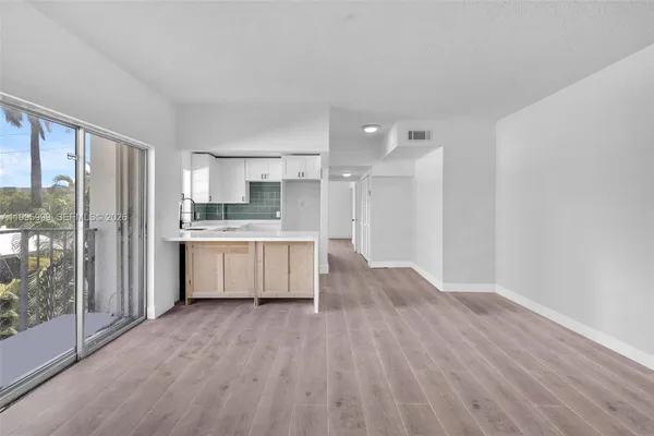 a large kitchen with a wooden floor and a large window