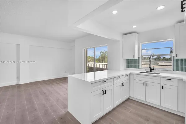 a kitchen with white cabinets and sink