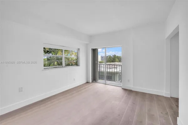 a view of a big room with wooden floor and windows