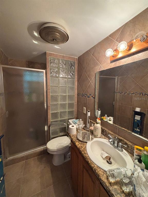 4447 Bahama Drive Hernando Beach, FL 34607 - Photo 11 of 31 a bathroom with a granite countertop sink a toilet a mirror and shower