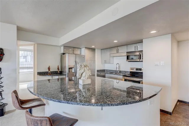a kitchen with stainless steel appliances kitchen island granite countertop a sink and cabinets