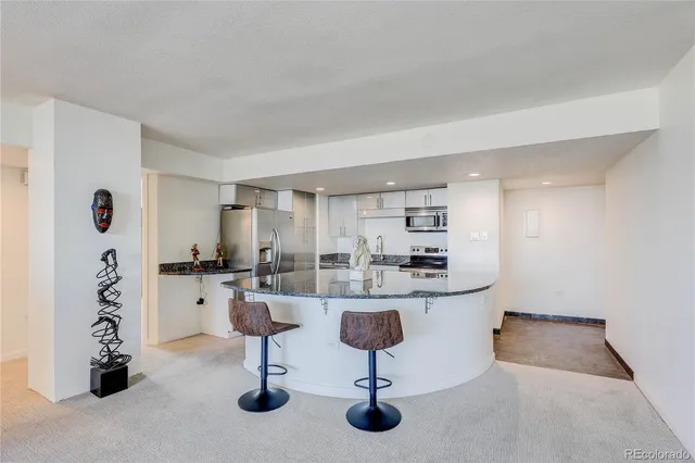 a kitchen with kitchen island granite countertop a sink a stove and cabinets