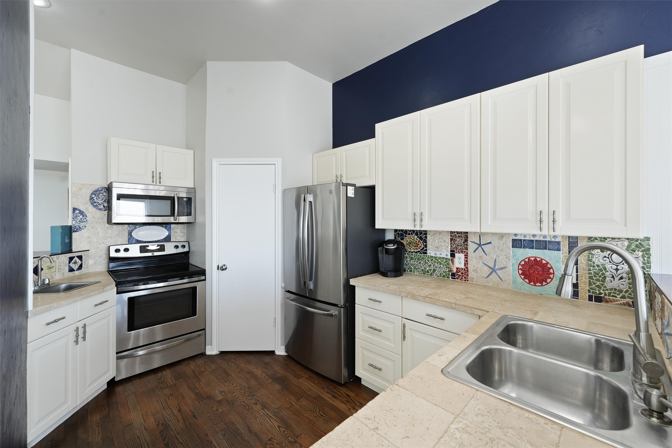 17607 Termini-San Luis Pass Road Galveston, TX 77554 - Photo 12 of 42 The kitchen includes modern stainless steel appliances, ample cabinet storage, and a cheerful mosaic backsplash. The unique tile design adds personality while celebrating the beach house theme.