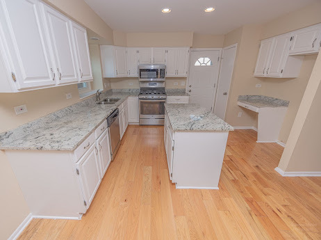 7 Boulder Ridge Court Bolingbrook, IL 60490 - Photo 16 of 44 a large kitchen with stainless steel appliances granite countertop a sink a stove top oven a counter space and cabinets