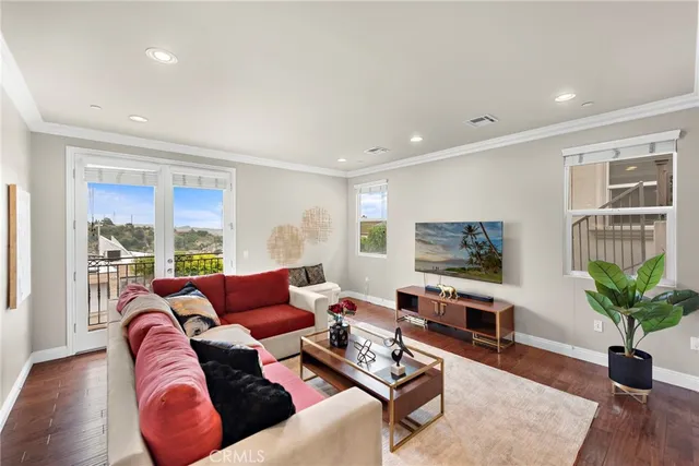 a living room with furniture potted plant and a flat screen tv
