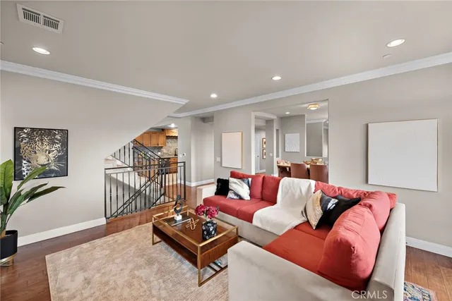 a living room with furniture a wooden floor and a potted plant