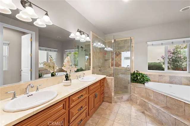 a spacious bathroom with a double vanity sink mirror and bathtub